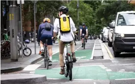  ?? Photograph: Jessica Hromas/The Guardian ?? Cyclists on a cycleway in Pitt Street, Sydney. The return of workers to Australia’s city centres after lockdowns has sparked increased jostling for kerb-side space.