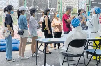  ?? Photo / AP ?? Residents line up to get tested at a coronaviru­s testing centre in Beijing.