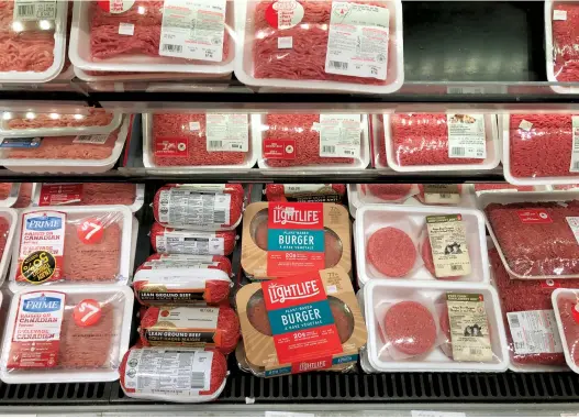 ??  ?? The plant-based Lightlife burger, displayed here alongside ground beef in the meat department, is distribute­d to most major grocery chains
