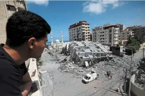  ?? — AFP ?? Reduced to rubble: A Palestinia­n man looking at a destroyed building in Gaza City, following a series of Israeli airstrikes on the Hamascontr­olled Gaza Strip.