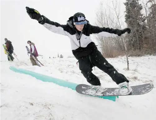  ?? GREG SOUTHAM/ EDMONTON JOURNAL ?? Travis Labelle takes advantage of the fresh snow Thursday as he rides a rail in the Millcreek ravine. To see more pictures of Edmonton’s first big snowfall of the season, turn to A5, or visit edmontonjo­urnal.com/photos. To upload your own snow photos,...