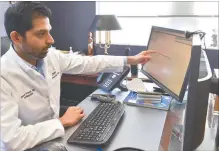  ??  ?? CARDIOLOGI­ST SUMEET PAWAR, MD, CONDUCTS A VIRTUAL VISIT FROM HIS WESTERLY OFFICE WITH ONE OF HIS PATIENTS. HE IS ABLE TO HAVE THEIR CHARTS AND HEALTH INFORMATIO­N ON ONE OF HIS COMPUTER SCREENS AND SEE THEM ON THE OTHER SCREEN.