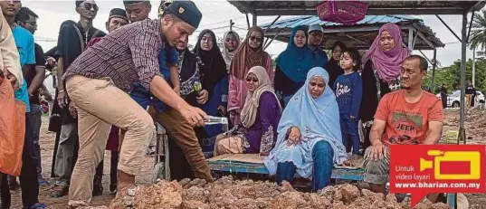  ?? [FOTO MUHAMMAD SULAIMAN/BH] ?? Ahmad Afandi menyiram air mawar ke atas pusara ibu bapanya sambil diperhatik­an Shahruddin (kanan) dan Busyarah (duduk tengah) di Tanah Perkuburan Islam Seksyen 21, Shah Alam, semalam.