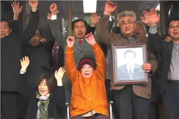  ??  ?? Kim Sung-joo (seated), a victim of forced labour by Japan during its colonial rule of the Korean peninsula from 1910 to 1945, and relatives of other victims react after a court’s verdict at the Supreme Court in Seoul. — AFP photo