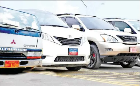  ?? HENG CHIVOAN ?? A right-hand drive van (left) and cars bearing number plates with RCAF and police insignia at a car park in Phnom Penh in August.