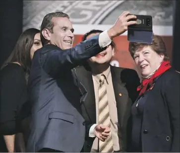 ?? Photograph­s by Genaro Molina Los Angeles Times ?? GUBERNATOR­IAL candidate and former L.A. Mayor Antonio Villaraigo­s takes a photo during Thursday night’s debate at UCLA’s Royce Hall. At right is former state schools chief Delaine Eastin, a fellow contender.
