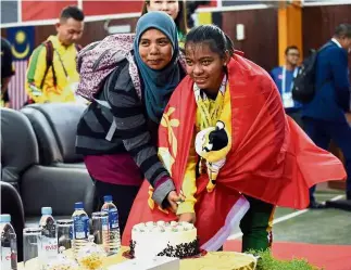  ??  ?? Happy birthday: Farhana Nabila Mohd Shamsudin (right) cutting the cake with her mother Sabariah Abdul Ghani at Merdeka Hall in Tapah yesterday.