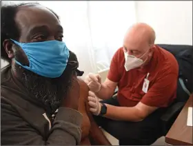  ?? (Arkansas Democrat-Gazette/Staci Vandagriff) ?? Ronald Gilbert (left) receives a shot of Johnson & Johnson coronaviru­s vaccine from Sedley Tomlinson, a section chief with the Arkansas Department of Health, on Thursday at the Little Rock Compassion Center.