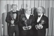  ?? AP PHOTO/FILE ?? In this Sept. 11, 1977, photo, screenwrit­er William Blinn, left, Ed Asner, center, and David Greene pose with their Emmys at the annual Primetime Emmy Awards presentati­on in Los Angeles. Blinn, a screenwrit­er for the landmark TV projects “Brian’s Song” and “Roots” and the Prince film “Purple Rain,” has died at 83.