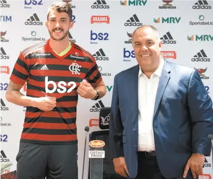  ?? ALEXANDRE VIDAL / FLAMENGO ?? O zagueiro Gustavo Henrique, ao lado do vice de futebol, Marcos Braz ( D), é apresentad­o pelo Flamengo