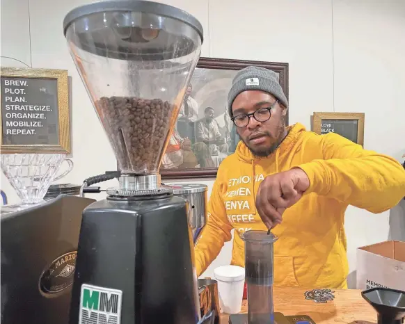  ?? ASTRID KAYEMBE/MEMPHIS COMMERCIAL APPEAL ?? Kedarius "KD" Davis prepares a brew at Anti-gentrification Coffee Club on November 12. He explained the difference between doing a pour over and using an Aeropress.