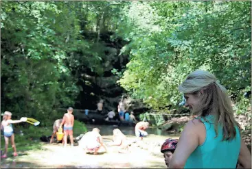  ?? Diane Wagner / Rome News-Tribune ?? Melinda Servick (right) catches up on the activities of her son Brady Servick, 7, at the creek where families and friends gather to cool off during the week-long camp meeting. TOP: Brad
Prater (left) and Brady Servick race around the Morrison...