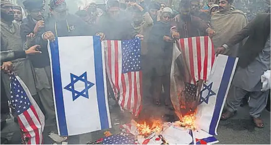  ?? (AP) ?? Ola de protestas. Manifestan­tes propalesti­nos quemaron en Pakistán banderas estadounid­enses e israelíes y repudiaron al jefe de la Casa Blanca.