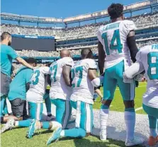  ??  ?? Dolphins players kneel during the national anthem in solidarity in response to words from President Trump.