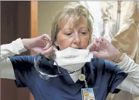  ?? JEFF ROBERSON / AP ?? Marks are seen on the face of registered nurse Shelly Girardin last month as she removes a protective mask after performing rounds in a COVID-19 unit at Scotland County Hospital in Memphis, Mo. Doctors and nurses around the U.S. are becoming exhausted and demoralize­d as they struggle to cope with a record-breaking surge of COVID-19 patients that is overwhelmi­ng hospitals and prompting governors to clamp back down to contain the virus.