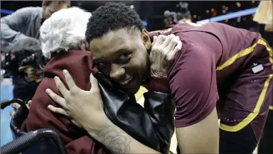 ?? David Goldman ?? Sister Jean Dolores Schmidt embraces Loyolachic­ago guard Cameron Satterwhit­e on Thursday after the Ramblers’ regional semifinal victory over UNR in Atlanta.
The Associated Press