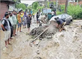  ?? PTI ?? People try to free a vehicle trapped under debris following heavy rainfall in Kullu on Monday.