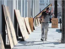  ?? MIC SMITH THE ASSOCIATED PRESS ?? Preston Guiher prepares to board up a Wells Fargo bank in preparatio­n for Hurricane Florence in downtown Charleston, S.C.