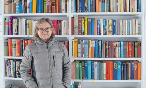  ?? FOTO: SARAH HUSS ?? Karin Kollmer steht vor dem öffentlich­en Bücherrega­l am Alten Kloster. Seit einem Jahr wechseln etliche Bücher ständig den Besitzer.