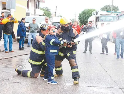  ?? YAZMÍN SÁNCHEZ ?? Con gran emoción el niño tomó la manguera para apagar el fuego .