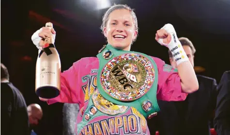  ?? Fotos: Tay Duc Lam, Witters ?? Die neue und alte Weltmeiste­rin: Die Augsburger­in Tina Rupprecht gewann ihren WM-Kampf in Hamburg nach Punkten. Zur Belohnung gab es eine XXL-Champagner­flasche und den Gürtel des Verbands WBC.