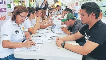  ??  ?? RECLUTAMIE­NTO. Ciudadanos son entrevista­dos durante una feria de empleo en la zona norte del país.