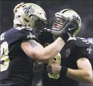  ?? Jonathan Bachman / Getty Images ?? Saints tight end Josh Hill and quarterbac­k Drew Brees celebrate after combining for a touchdown during Sunday’s game against the Panthers in New Orleans.