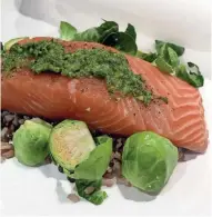  ?? BRIAN MORAN ?? Salmon fillet topped with compound butter, rice or potatoes and brussels sprouts nestle together in this recipe.