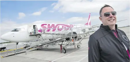  ??  ?? Steven Greenway, president and CEO of Swoop Airlines, in front of one of the airline’s Boeing 737 planes in Hamilton.