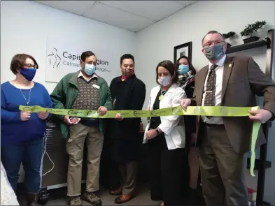  ?? MELISSA SCHUMAN — MEDIANEWS GROUP ?? With members of the Capital Region Chamber supporting her, Laura Brown prepares to cut the ribbon for Capital Region Calmare and Massage.