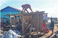  ?? ALREN BERONIO/AFP VIA GETTY IMAGES ?? Residents of the Philippine­s construct a makeshift shelter Thursday after their house was destroyed during a typhoon.