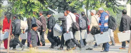  ?? SUBHANKAR CHAKRABORT­Y/HT PHOTO ?? Polling officers carrying EVMs and ballot boxes from the distributi­on centre at Ramabai Ambedkar Park, Lucknow to polling booths on Saturday ahead of the second phase polling of civic elections.