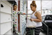  ?? JACQUELYN MARTIN — THE ASSOCIATED PRESS FILE ?? Roberto, 5, stands in their doorway in his pajama’s as his mother Arely Martinez carries in a bag of food in Baltimore on April 14.