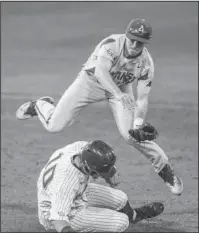  ?? The Associated Press ?? INTERFEREN­CE: Ole Miss’ Tyler Keenan (10) is called for interferen­ce as he tries to break up a double play against Arkansas’ Carson Shaddy during the Rebels’ 5-4 victory Friday night at Swayze Field. Bruce Newman/Oxford Eagle.