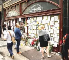  ?? — Reuters photo ?? People look at tributes to Bourdain outside Brasserie Les Halles in New York, on Monday.