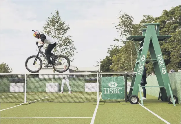  ??  ?? 0 Net gain: Danny Macaskill, king of the stunt cyclists, performs a daredevil ride, blocking Tim Henman’s efforts to play tennis at Wimbledon