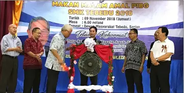  ??  ?? Manyin (third left) hits the gong to declare open the dinner as others look on.