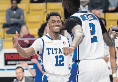  ?? MATHEW MCCARTHY RECORD STAFF ?? K-W Titans’ Juwan Miller (12) congratula­tes teammate Akeem Ellis in NBL action against the Island Storm at the Aud on Tuesday.
