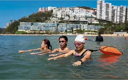  ?? — AFP ?? Team effort: Domestic helpers from the Philippine­s swimming at Repulse Bay in Hong Kong.