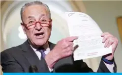  ?? AFP ?? WASHINGTON: Senate Minority Leader Chuck Schumer holds a transcript of the phone call between US President Donald Trump and Ukraine President Volodymyr Zelensky, during a press conference at the US Capitol yesterday. —
