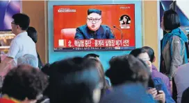  ?? [AP PHOTO] ?? People watch a TV screen showing an image of North Korean leader Kim Jong Un during a news program Saturday at the Seoul Railway Station in Seoul, South Korea. The signs read: “North Korea says it has suspended nuclear tests.”