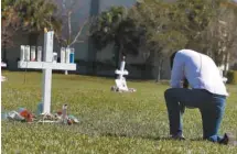  ?? RHONA WISE AGENCE FRANCE-PRESSE ?? Un homme se recueille devant un mémorial à la mémoire des victimes de la fusillade de l’école Marjory Stoneman Douglas.