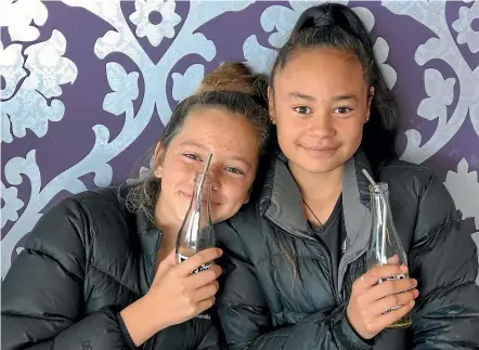  ?? BRIANNA MCILRAITH/STUFF ?? Puketapu School pupils Millah West and Kyra-Jae Paki, both 12, try out the reusable straws they have donated to the White Pear Cafe in Bell Block after they noticed a lot of plastic straw waste.