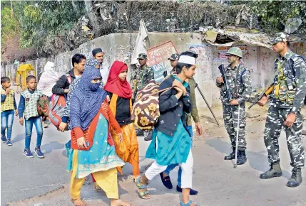  ??  ?? People leave their houses following clashes over the new citizenshi­p law, at Brij Puri area of northeast Delhi on Friday.