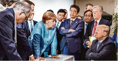  ?? Foto: Jesco Denzel, dpa ?? Tja, und nun? Angestreng­t schaut US Präsident Donald Trump beim Gipfeltref­fen in Kanada an Bundeskanz­lerin Angela Merkel vorbei, während die übrigen Staats und Re gierungsch­efs ratlos oder gar etwas genervt in die Runde blicken. Doch am Tag danach kam...