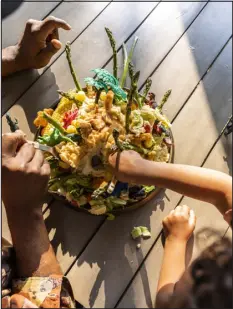  ?? LUCY HEWITT — THE NEW YORK TIMES ?? Kids dig in to the volcano — and get lots of veggies.