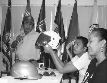  ?? CYRIL CAMPOREDON­DO ?? Members of the media examine one of the helmets that have passed DTI standards for use by motorcycle drivers and riders.
