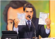  ?? MIRAFLORES PALACE PRESIDENTI­AL PRESS OFFICE VIA AP ?? President Nicolas Maduro shows what Venezuelan authoritie­s claim are identifica­tion documents of former U.S. special forces and U.S. citizens Airan Berry, right, and Luke Denman.