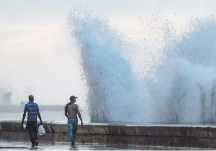  ??  ?? During the fall and winter, cold fronts often drench Havana’s Malecon with high waves.