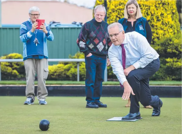  ?? Picture: Jason Edwards ?? Prime Minister Scott Morrison is snapped by a local as he tries his hand at bowling in Beauty Point, Tasmania, on Thursday.